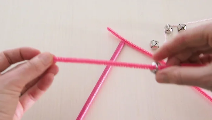 Push the jingle bells along the dowel, arranging them as desired, and twist the pipe cleaner around the stick to secure them.