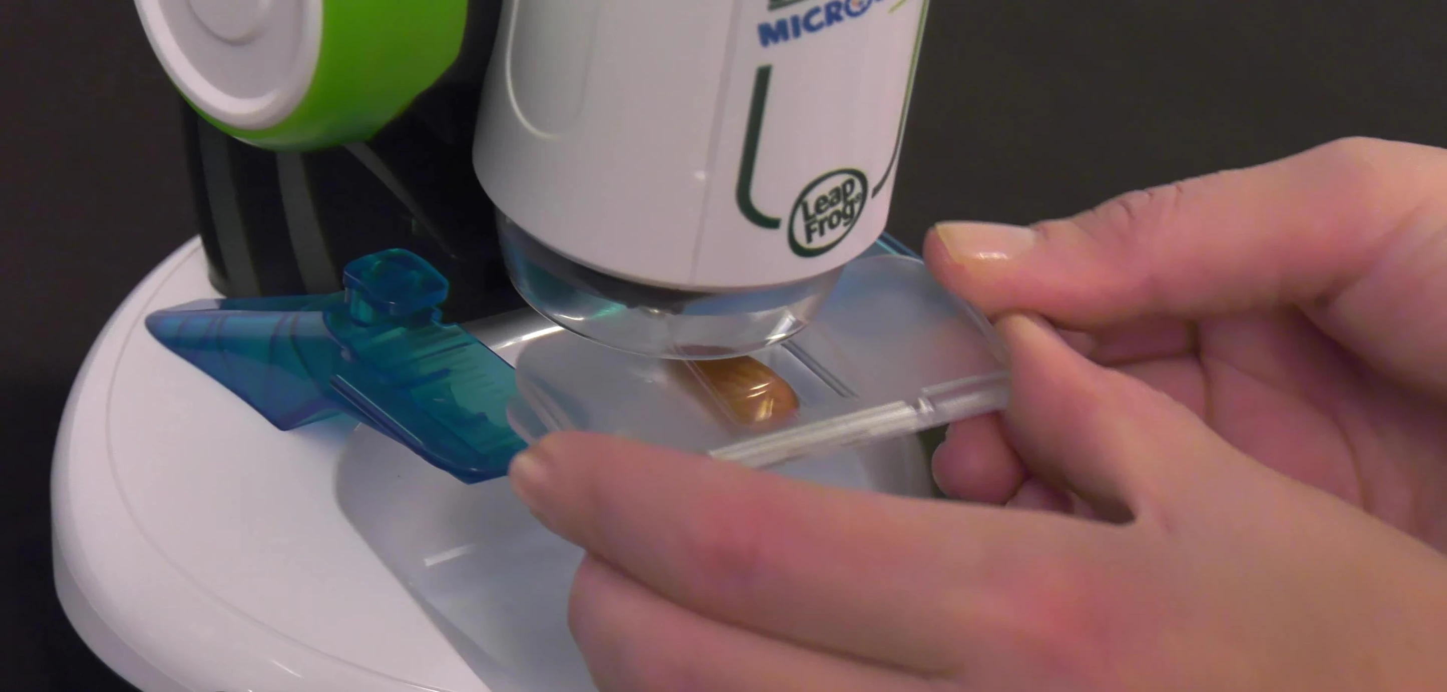 A child using the microscope to view a sample.
