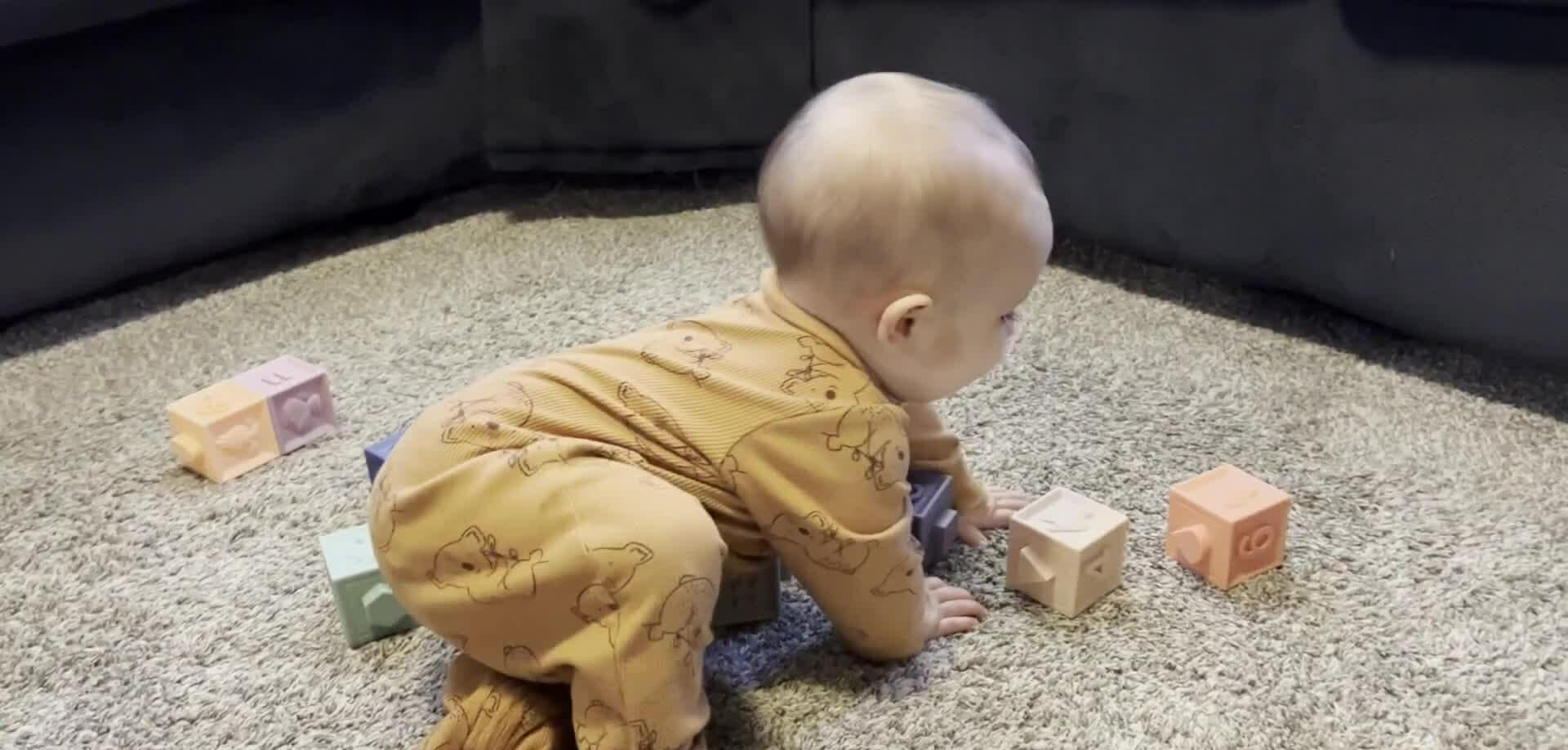 Close-up of a baby playing with the soft learning cubes.