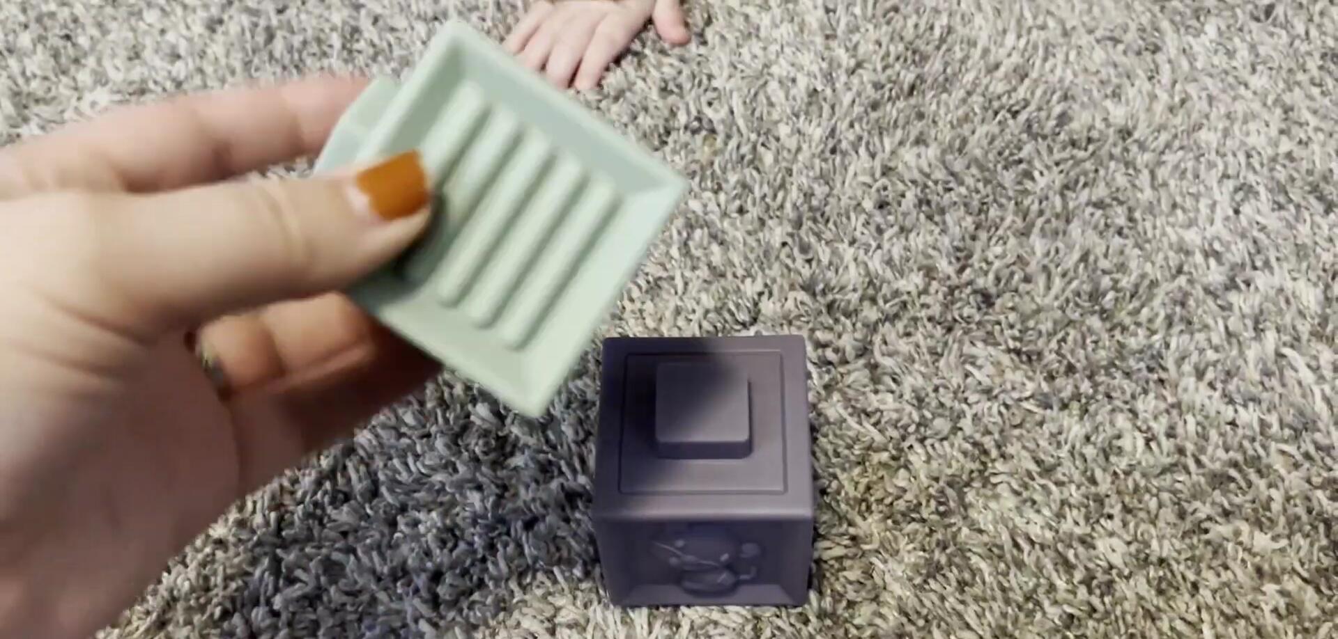 Baby knocking down the stacked cubes.