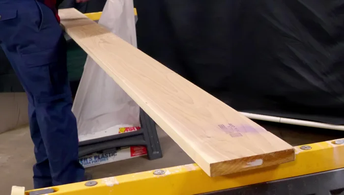 Create the tube: Lay the plastic sheet on a wood plank. Attach one edge with masking tape. Find the opposite edge, bring it around the board and join it to the first edge using glue tape. Repeat the process to extend the tube to the desired length (e.g., 50ft).