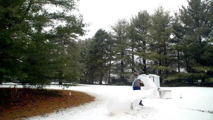 Prepare for lift-off: Use two hula hoops to keep the mouth of the tube open. Tie the other end of the tube closed.