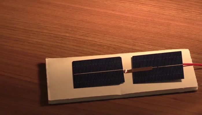 Attach the last wire to the exposed copper wire of the second clip lead and place it over the white contact on the second solar cell.