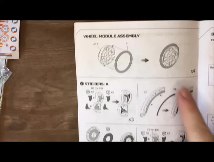 Add final stickers and rubber band treads to complete the robot.
