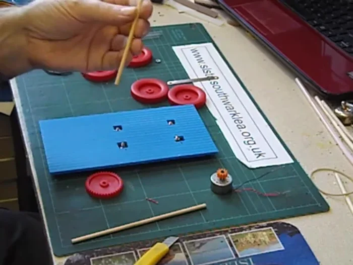 Fix the driven gear to the straw using glue.