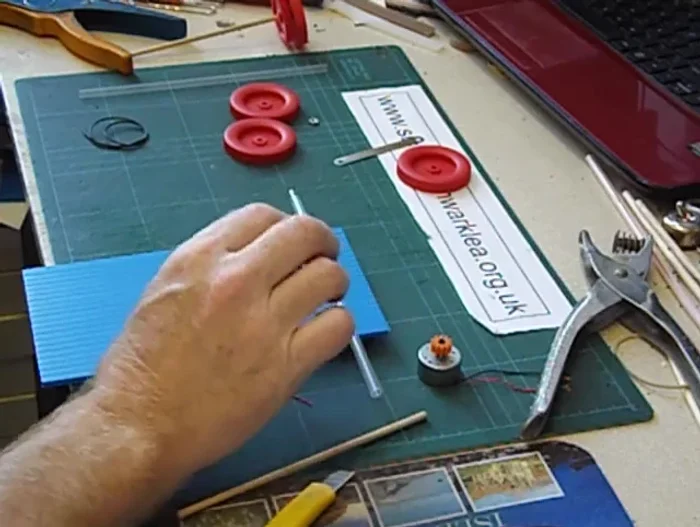 Fix the driven gear to the straw using glue.