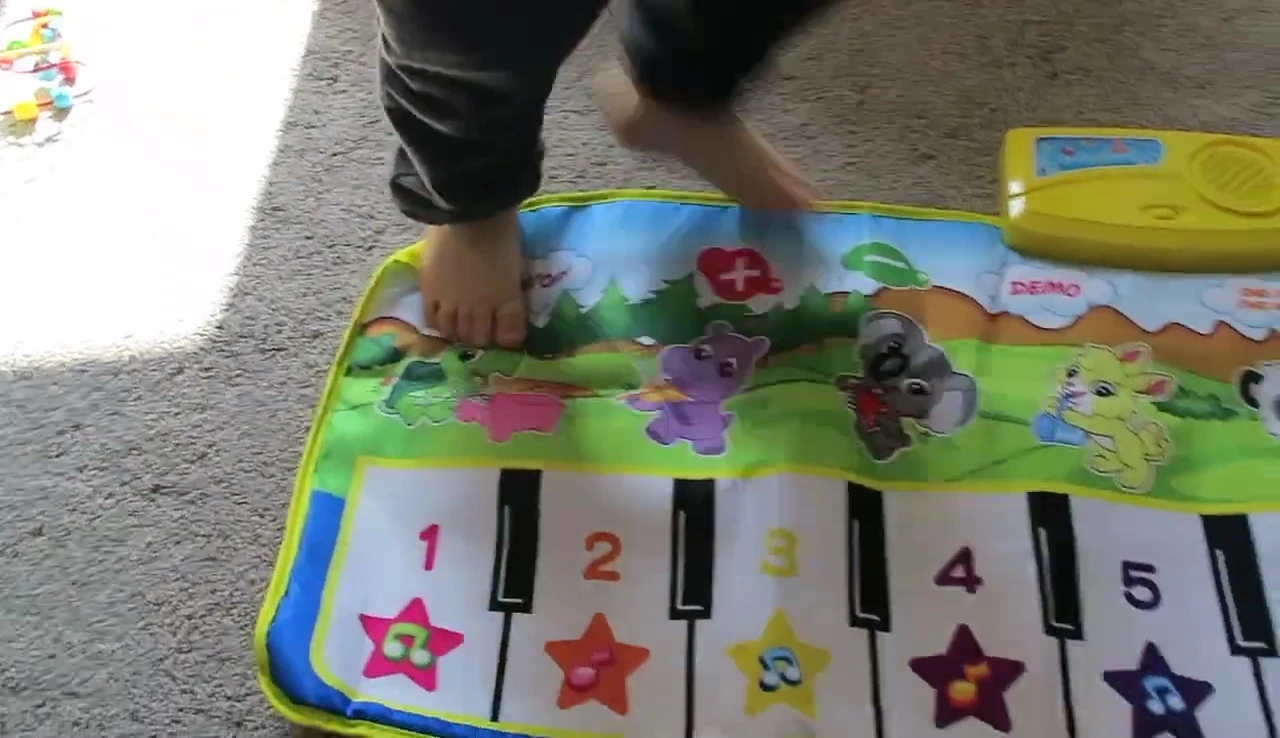 Grayson happily walking and playing on the mat.