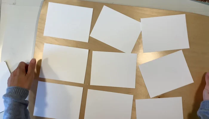 Arrange and secure the cards: Use artist's tape to secure the cards to a painting board. This is optional but helps maintain a border and keeps the cards in place.