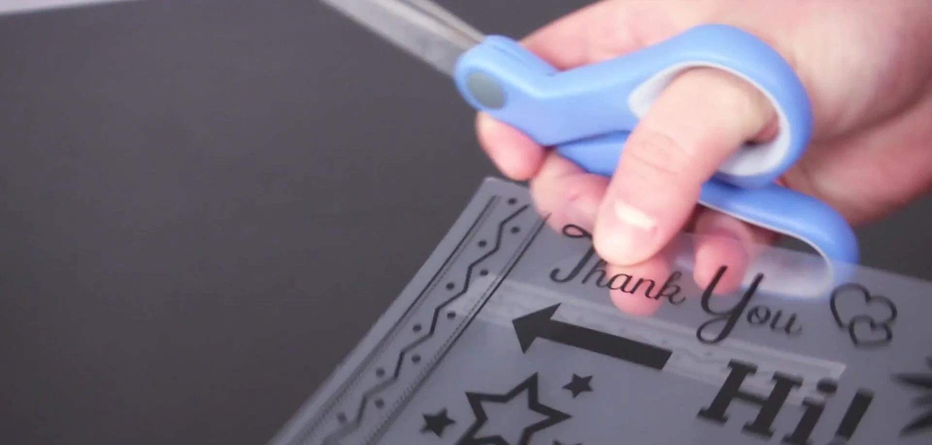 Person cutting out shapes from a stencil.