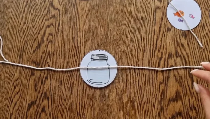 Glue the opposite side of the picture (upside down, aligning the black dots) to the other side of the disc.