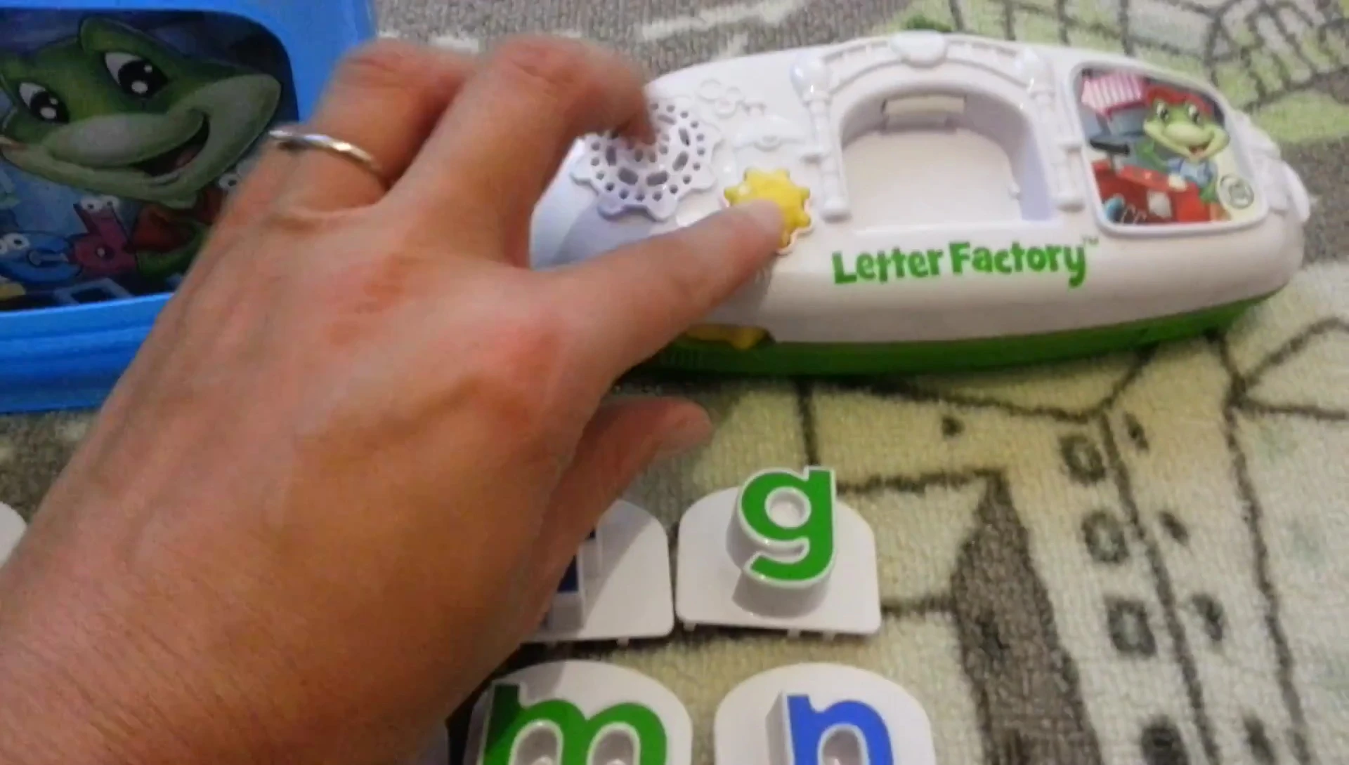The presenter begins reciting the alphabet, A through S.