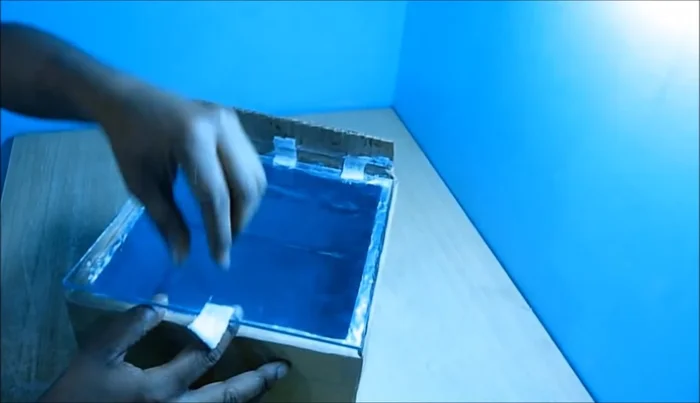 Create the reflector: Cut a piece of cardboard to the size shown and cover it with aluminum foil. Fold the cardboard to form a reflector.