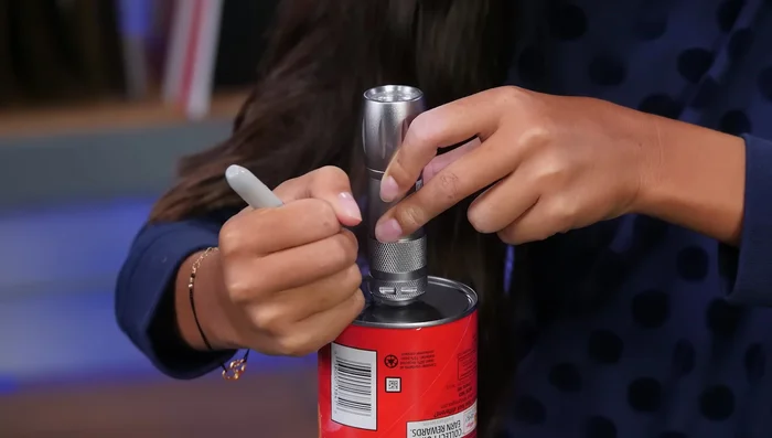 Cut the rim off an extra Pringles lid and cut a hole for the flashlight, securing it with tape.
