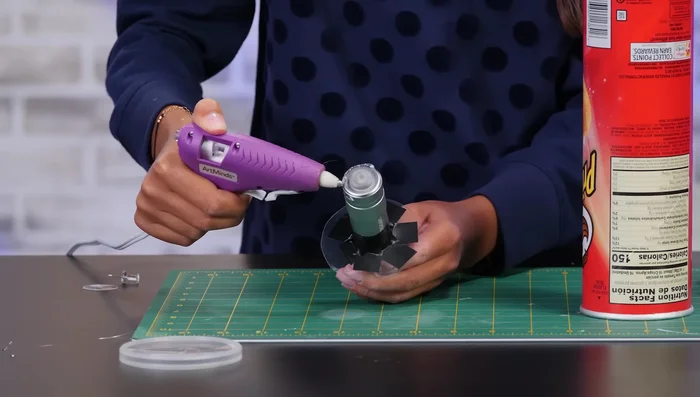 Use double-sided tape to attach the symbol to the inside of the lid, reassemble the can.