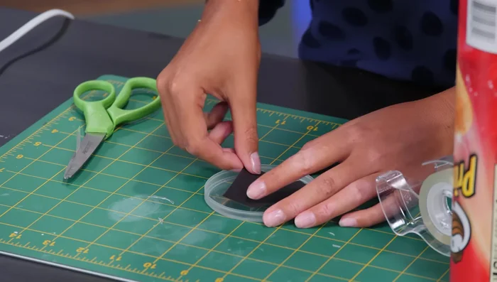 Use double-sided tape to attach the symbol to the inside of the lid, reassemble the can.