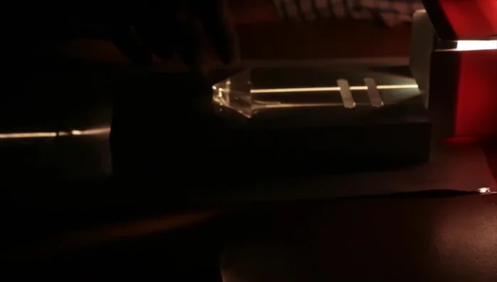 Observe the internal reflection of the light within the prism, resulting in the light exiting parallel to the incident ray.