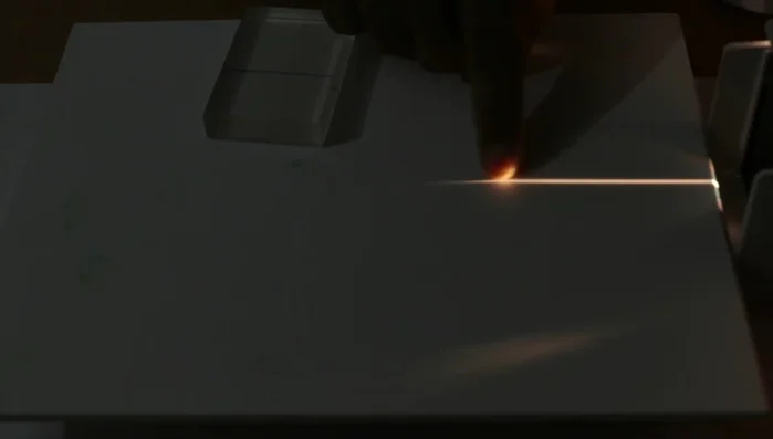 Set up the light source and place the acrylic slab in the path of the light.