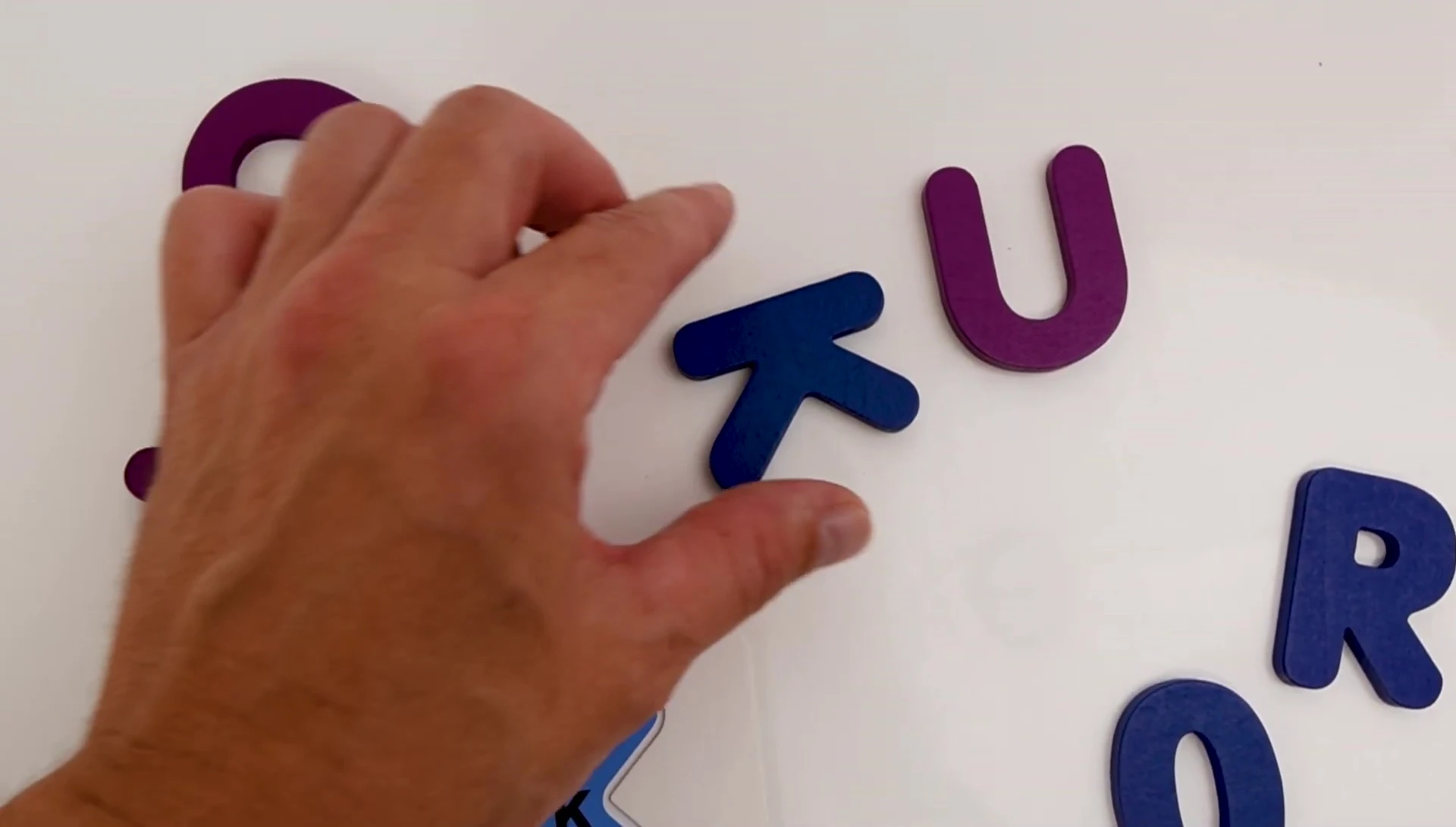 The child finds the letter 'K' block.