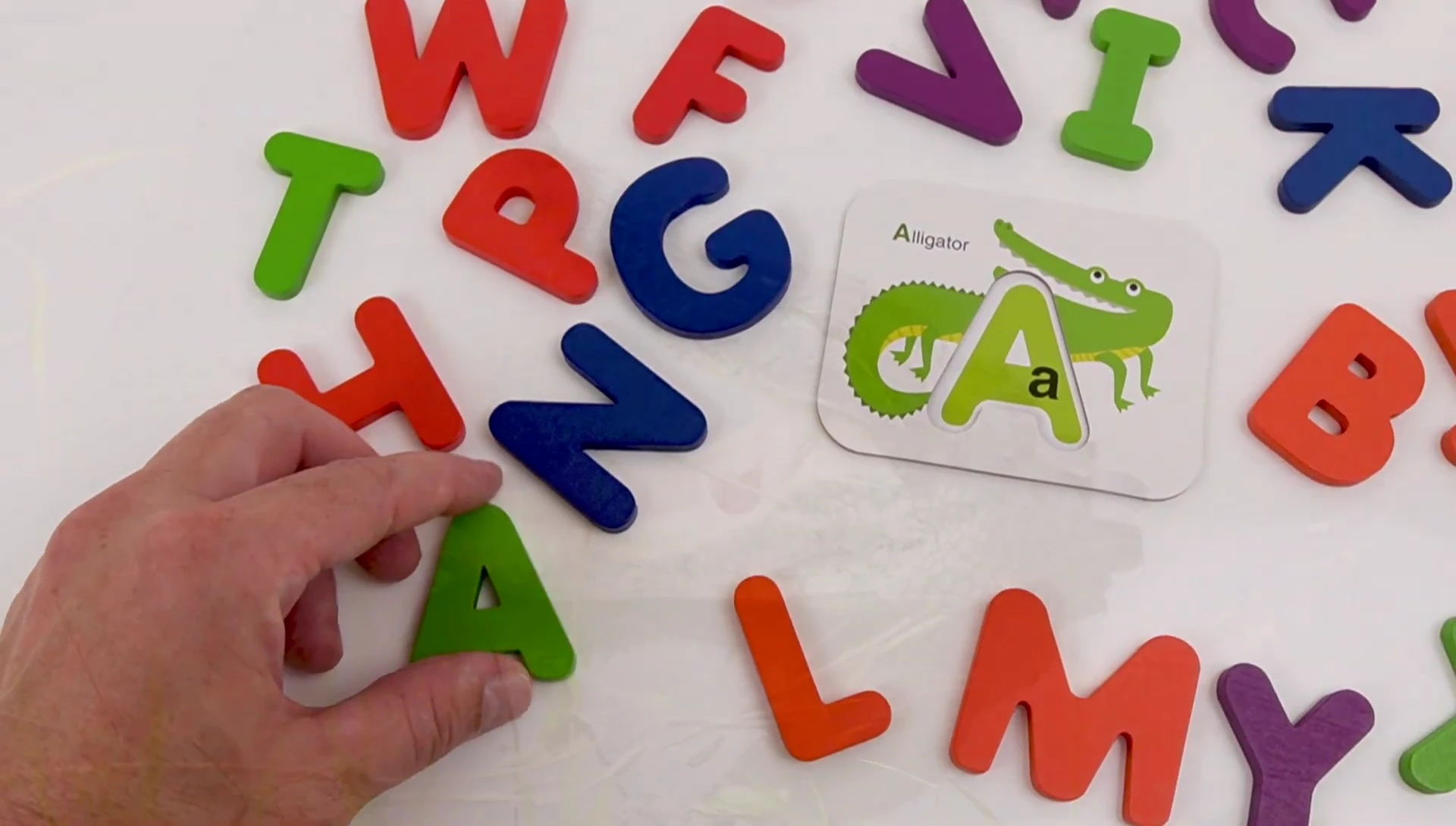 The child finding the letter 'A' block.