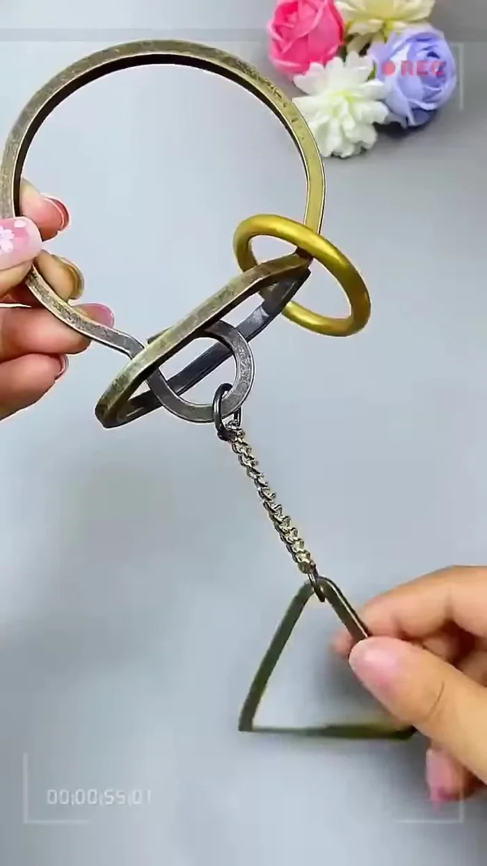 Remove the triangular ring: Carefully lift the triangular ring from the bottom and pass it upwards, out of the chain.