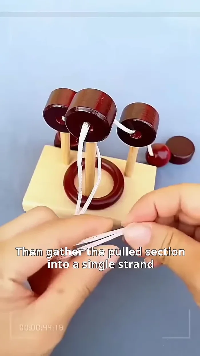 Gently pull the left cord outward and gather it into a single strand.