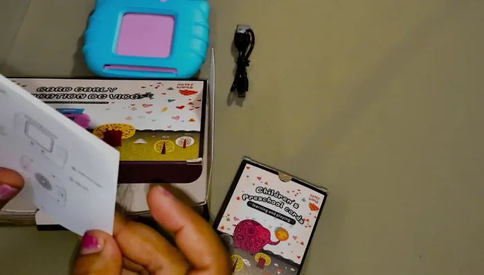 Identify the components: charger, cards, and manual.