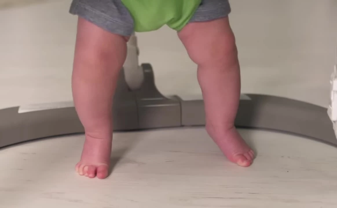 Baby's feet touching the floor in the Jumperoo.